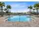 A community pool with lounge chairs and palm trees offers the perfect place to relax on a hot day at 13807 Tybee Beach Ln, Orlando, FL 32827