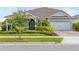 Charming single-story home with a stone facade, well-manicured landscaping, and a two-car garage at 13807 Tybee Beach Ln, Orlando, FL 32827