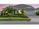 Charming single-story home with well-manicured landscaping, stone accents, and an attached two-car garage at 13807 Tybee Beach Ln, Orlando, FL 32827