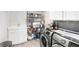 Well-organized laundry room with modern washer and dryer, shelving, and storage cabinets at 13807 Tybee Beach Ln, Orlando, FL 32827