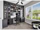 Home office featuring custom built-in shelving, a desk area, and a large window with a view at 13807 Tybee Beach Ln, Orlando, FL 32827