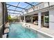 Swimming pool with outdoor kitchen and living space in screened enclosure at 13807 Tybee Beach Ln, Orlando, FL 32827