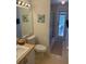 Bathroom featuring a toilet, sink, large mirror, and shower, with a door to the outside at 15910 Mercott Ct, Clermont, FL 34714