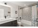 Well-lit bathroom featuring a gray vanity, toilet, and tub with gray accent wall at 1624 E Livingston St, Orlando, FL 32803