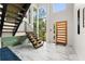 Bright foyer boasts soaring ceilings, statement staircase, and stylish wood and steel elements at 1624 E Livingston St, Orlando, FL 32803