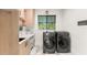 Bright laundry room with modern washer and dryer, ample cabinet space, and granite countertops at 1624 E Livingston St, Orlando, FL 32803
