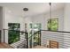 Modern staircase with black railing, wood steps, and abundant natural light from large windows at 1624 E Livingston St, Orlando, FL 32803
