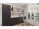 Modern wet bar with dark cabinetry, light countertops, open shelving, and a built-in wine cooler at 1624 E Livingston St, Orlando, FL 32803