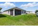 Well-maintained backyard and exterior view of home with screened-in porch and central air unit at 1703 Daystar Dr, Haines City, FL 33844