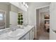 Bathroom featuring double sinks, granite counters, modern lighting, and decorative plants at 1703 Daystar Dr, Haines City, FL 33844