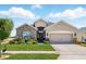 Charming single-story home with a stone facade, landscaped yard, and a two-car garage at 1703 Daystar Dr, Haines City, FL 33844