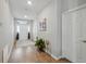 Bright hallway with wood floors, leading to the front door, adorned with tasteful decorations at 1703 Daystar Dr, Haines City, FL 33844