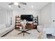 Bright living room with plush sofas, glass coffee table, and ladder shelving for a modern and inviting feel at 1703 Daystar Dr, Haines City, FL 33844