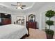 Large primary bedroom with carpet, tray ceiling, ceiling fan, and wood furniture at 1703 Daystar Dr, Haines City, FL 33844