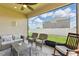 Relaxing covered patio with outdoor seating, ceiling fan and peaceful backyard view at 1703 Daystar Dr, Haines City, FL 33844