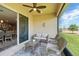 Covered patio with wicker furniture and ceiling fan overlooks the backyard at 1703 Daystar Dr, Haines City, FL 33844