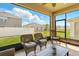 Screened-in patio with wicker seating offers relaxing outdoor space with a view of the backyard at 1703 Daystar Dr, Haines City, FL 33844