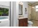 Bathroom vanity with granite countertop and shower with tile surround and glass door at 1840 Bryan Ave, Winter Park, FL 32789