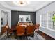 Formal dining room with black accent wall, elegant lighting, and decorative owls at 1840 Bryan Ave, Winter Park, FL 32789