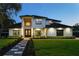 Elegant two-story home boasts manicured landscaping, a walkway, and impeccable lighting at 1840 Bryan Ave, Winter Park, FL 32789