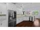 Eat-in kitchen features stainless appliances, white cabinets, granite countertops, and a view to the dining area at 1840 Bryan Ave, Winter Park, FL 32789