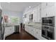 Bright eat-in kitchen with stainless appliances, white cabinetry, granite countertops, and dark wood floors at 1840 Bryan Ave, Winter Park, FL 32789