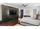 Main bedroom featuring hardwood floors, ceiling fan, modern TV, and an ensuite bathroom at 1840 Bryan Ave, Winter Park, FL 32789