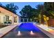 A luxurious pool features water fountains and a fire pit, all set against a backdrop of lush tropical landscaping at 1840 Bryan Ave, Winter Park, FL 32789