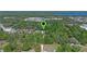 Aerial shot of property among the trees with view of nearby road, lake, and commercial businesses at 20 Lido Rd, Winter Springs, FL 32708
