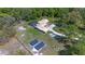 Aerial view of a home with a screened pool, solar panels, shed, and lush greenery at 20 Lido Rd, Winter Springs, FL 32708