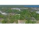 Overhead view of home among the trees with view of nearby road, lake, and commercial businesses at 20 Lido Rd, Winter Springs, FL 32708