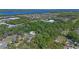 Aerial shot of property among the trees with view of nearby road, lake, and commercial businesses at 20 Lido Rd, Winter Springs, FL 32708
