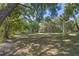 Large backyard with mature trees, providing ample shade on a sunny day at 20 Lido Rd, Winter Springs, FL 32708