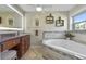 Bright bathroom with a soaking tub, glass shower, and marble countertops at 20 Lido Rd, Winter Springs, FL 32708