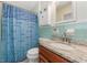Bathroom with blue tiling, white patterned shower curtain, and wood vanity at 20 Lido Rd, Winter Springs, FL 32708