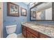 Bathroom with blue walls, wood cabinets, granite countertops, and patterned shower curtain at 20 Lido Rd, Winter Springs, FL 32708