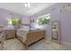 Cozy bedroom with tiled floor, two windows letting in natural light, and a wooden framed mirror at 20 Lido Rd, Winter Springs, FL 32708