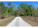 Long gravel driveway and wooden fence leading to the property at 20 Lido Rd, Winter Springs, FL 32708