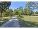 Long driveway leading to the property, framed by mature trees and lush landscaping at 20 Lido Rd, Winter Springs, FL 32708