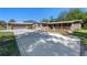 Exterior elevation highlighting the stone accents, covered porch, mature trees and driveway at 20 Lido Rd, Winter Springs, FL 32708