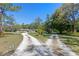 A ranch home in the middle of a large yard with a split driveway and tropical landscaping at 20 Lido Rd, Winter Springs, FL 32708