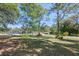 Spacious front yard with a well-maintained lawn, mature trees, and visible solar panels on the property at 20 Lido Rd, Winter Springs, FL 32708