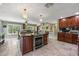 Well-equipped kitchen with a central island, stainless steel oven, dark cabinets, and tile flooring at 20 Lido Rd, Winter Springs, FL 32708