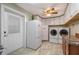 Well-equipped laundry room with abundant white cabinets, appliances, and counter space at 20 Lido Rd, Winter Springs, FL 32708