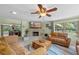 Bright and airy living room featuring a fireplace, ceiling fan, and views of the outdoor scenery at 20 Lido Rd, Winter Springs, FL 32708
