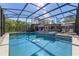 Screened in pool with beautiful blue tile and a jacuzzi with outdoor seating and umbrellas at 20 Lido Rd, Winter Springs, FL 32708