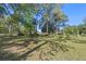 An expansive back yard with trees and a glimpse of the house in the background at 20 Lido Rd, Winter Springs, FL 32708