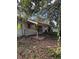 Overgrown front yard showing abandoned home with boarded windows and a covered porch in need of repair at 2115 Messina Ave, Orlando, FL 32811