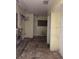 Empty Living Room with boarded window and outdated kitchen at 2115 Messina Ave, Orlando, FL 32811