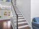 Staircase featuring hardwood steps, white risers, and a wood railing, leading to the home's entry at 226 Ringwood Dr, Winter Springs, FL 32708